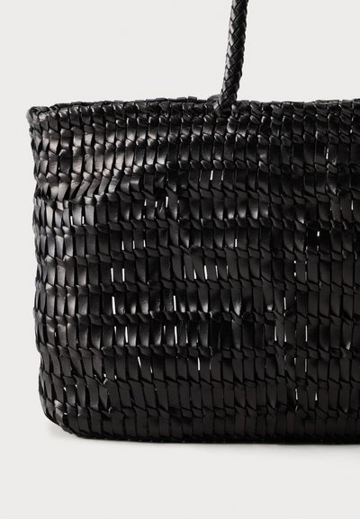 Μαύρη υφαντή τσάντα σε στυλ καλάθι με ένα μονό πλεγμένο χερούλι σε απλό φωτεινό φόντο.