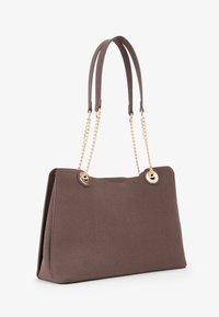 Borsa a tracolla marrone texture con doppie cinghie marroni e dettagli in catena color oro. Presenta una hardware rotonda dorata nella parte superiore. Forma rettangolare.