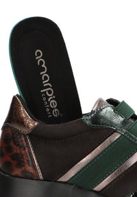 Zapatilla de cuero con un diseño en marrón, verde y metálico. Presenta texturas mixtas, bandas elásticas y una plantilla acolchada.