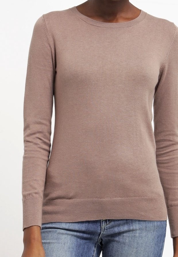 Ljust rosa långärmad tröja med ribbad rundhalsning och åtsittande ärmmuddar, tillverkad av mjukt material, i kombination med denimjeans.