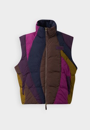 Prsluk s punim kragnom koji sadrži geometrijske blokove boja u ljubičastoj, mornarsko plavoj, smeškastoj i žutoj. Uključuje zatvaranje na patent zatvarač i bočne džepove.