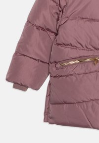 Padded jacket in mauve, featuring a zippered pocket with gold hardware, ribbed cuffs, and a soft, smooth texture.