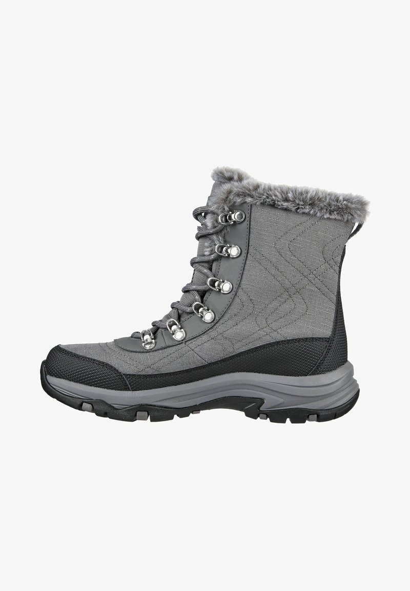 Bota de senderismo gris con parte superior de tela texturada, cuello de piel sintética, ojetes metálicos y suela de goma negra con dibujo de tracción.