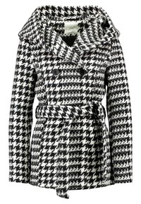 Cappotto houndstooth bianco e nero con ampio colletto, chiusura a doppiopetto con bottoni e cintura da legare in vita. Tessuto strutturato.