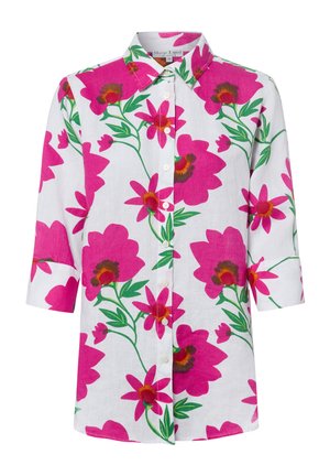 Wit overhemd met knopen en driekwart mouwen, met grote felroze bloemen en groene bladeren in een gedurfd bloemenpatroon.