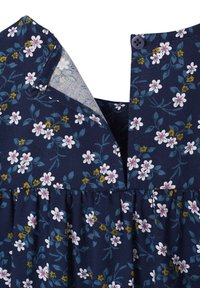 Navyblaues Blumenkleid mit kleinen weißen und gelben Blumen, einer Knopfverschluss am Ausschnitt und einer gerafften Taille für zusätzliche Textur.