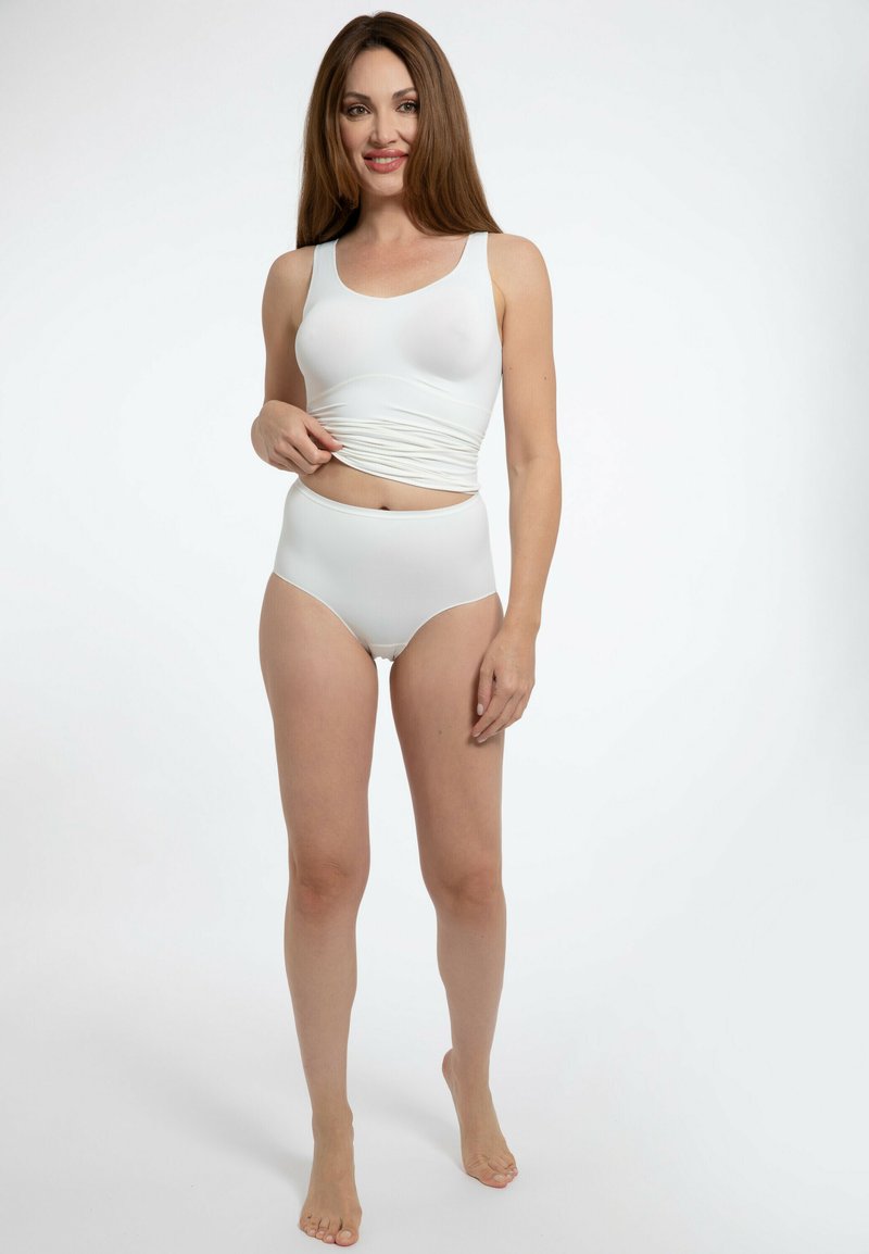 Weiße nahtlose Tanktop mit breiten Trägern und gerafftem Vorderteil, kombiniert mit hochgeschnittenen weißen Unterhosen. Glattes Material und figurbetontes Design.
