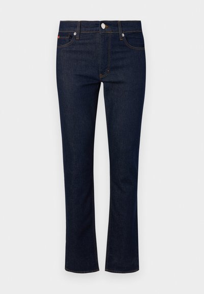 Jeansi din denim cu o nuanță albastru închis, design cu picioare drepte, cinci buzunare și cusături contrastante. Prezintă un sistem de închidere cu nasture frontal.