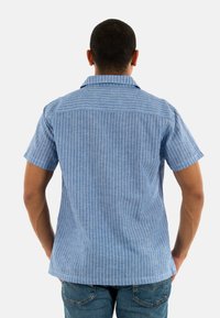 Korte mouwen overhemd in lichtblauw met witte verticale strepen, met een klassieke kraag en een relaxte pasvorm. Textuurstof met een casual ontwerp.
