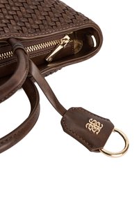 Brązowa, pleciona torba skórzana z rogiem i złotym zamkiem błyskawicznym oraz przymocowaną skórzaną metką z złotym logo i detalem w postaci pierścienia na białym tle.