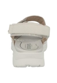 White sandal with adjustable strap, fabric upper, cushioned insole, and textured sole. Features embossed logo on the footbed.
