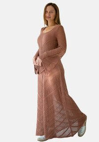 Długa, rdzawoczerwona dzianinowa sukienka z dopasowanym gorsetem i rozporkami, z geometrycznym wzorem i bocznymi szczelinami.