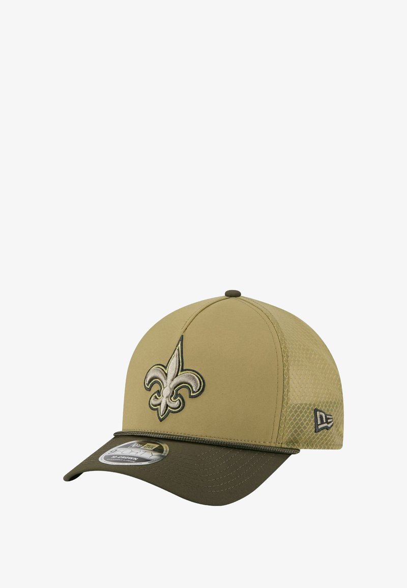 Beige Kappe mit gesticktem schwarzem und goldenem Fleur-de-Lis-Logo. Mesh-Seitenteile, strukturierte Vorderseite und ein dunkler olivgrüner Schirm.