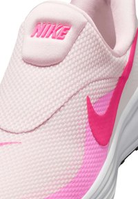 Scarpa slip-on Nike in mesh rosa chiaro, con tomaia testurizzata, accenti rosa vivaci e un logo rosa prominente sulla linguetta.