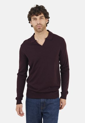 Burgundy long-sleeve polo sweater with a v-neck and a soft texture. Paired with blue denim jeans, minimalistic design and no visible patterns.