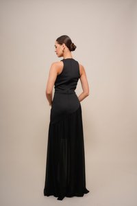 Black evening gown featuring a fitted bodice and a flowing, sheer skirt. Asymmetrical design with a zipper at the back and minimal detailing.