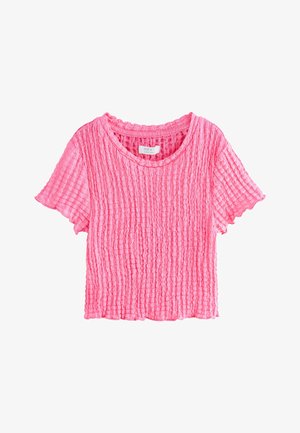 Pink kortærmet, struktureret, strikket cropped top med rund halsudskæring og diskrete flæsekant, vist på hvid baggrund.