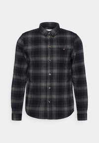 Black and green plaid shirt made of flannel, featuring a button-up front, long sleeves, and a single chest pocket with a button detail.