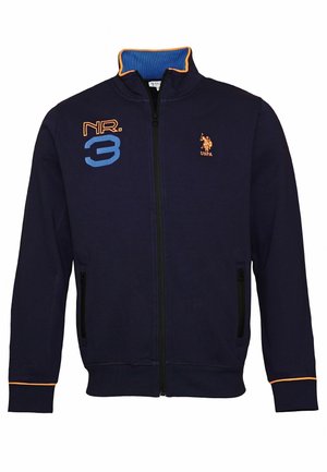 Navyblå jakke med lynlås med orange kant, broderet "NR. 3" i blå og orange på venstre bryst og orange USPA-logo på højre bryst.