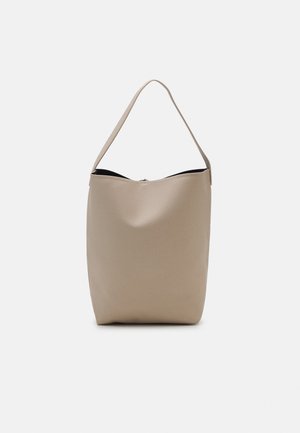 Sac seau en cuir beige texturé avec une seule bandoulière, ouverture sur le dessus et bord supérieur légèrement incurvé.