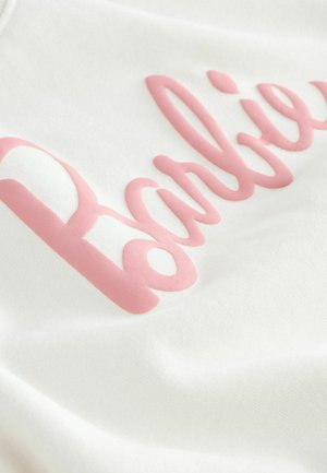 Hvidt stof med et hævet pink "Barbie" logo i kursiv skrifttype, der viser en glat tekstur og jævn farvefordeling.