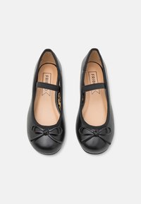 Bailarinas negras con punta redondeada, ribete elástico y un lazo decorativo en la parte delantera. El interior presenta un diseño de estampado de leopardo.