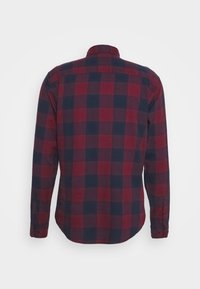 Camicia a maniche lunghe a quadri rossa e blu navy con polsini a bottoni e orlo arrotondato; realizzata in tessuto morbido e caratterizzata da un colletto.