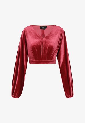 Punane sametist lühike topp, millel on pikad, puhviliigesed varrukad, V-kujuline kaelus ja volditud detailid rinnal. Pehme tekstuur, sobiv siluett.