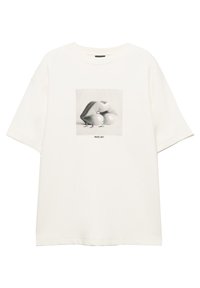 T-shirt bianca in tessuto morbido con una grafica artistica di labbra e due figure sotto il testo "MAKE ART" all'interno di un quadrato. Maniche corte.