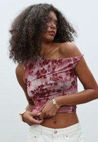 Bordeaux- und rosa Batik-Crop-Top mit einem schulterfreien Design. Weicher, fließender Stoff, schmale Silhouette und dezente Raffung an den Schultern.