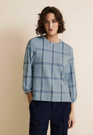 Haut à carreaux bleu clair avec des manches trois-quarts, un col rond et une texture à motifs, associé à un pantalon bleu marine.