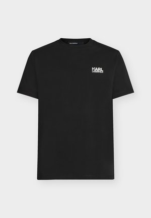 Μαύρο T-shirt με κοντό μανίκι και λευκό λογότυπο "KARL LAGERFELD" στην πάνω αριστερή πλευρά του στήθους, εμφανιζόμενο σε απλό φωτεινό φόντο.