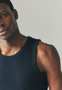 Marineblaues, geripptes Tanktop mit runden Ausschnitt und breiten Trägern, aus einem glatten Stoff gefertigt, der den Schulter- und Armbereich betont.