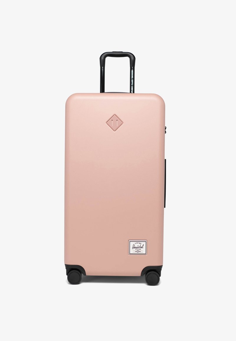 Tvrda kofer u svijetlo roza boji s crnim detaljima, sklopiva ručka, četiri crna kotača i prednja oznaka brenda. Velik i pravokutan dizajn.
