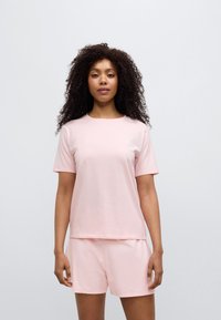 Ροζ βαμβακερό t-shirt με κοντά μανίκια και κλασικό στρογγυλό λαιμό, συνοδευόμενο από ταιριαστά σορτς. Μινιμαλιστικός σχεδιασμός, χωρίς σχέδια.