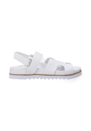 White sandal featuring a textured leather upper, open-toe design, adjustable ankle strap, and a ridged rubber sole. Smooth finish.
