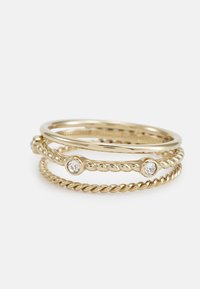 Guldtonede stablede ringe med glatte, snoede og perlede designs, med en klar sten accent på den midterste ring.