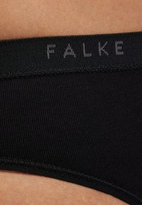 Zwarte elastische tailleband met het merk "FALKE" in een lichtgrijze lettertype, gecombineerd met zachte, geribbelde stof met een gladde textuur.