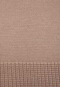 Strickgewebe in einem sanften Rosa-Ton, mit einer glatten Oberflächenstruktur und einem gerippten unteren Rand, der seine Dehnbarkeit und Wärme betont.