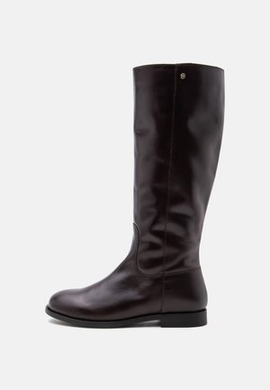 Botte haute en cuir marron foncé avec petit talon, bout arrondi et coutures discrètes sur fond uni.