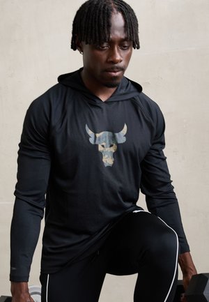 Black long-sleeve hoodie with a camo bull graphic, paired with black pants featuring white stripes. The fabric is textured and fitted.