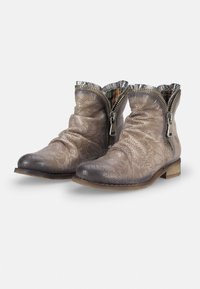 Botas de tobillo de cuero perforado en tono marrón y gris, con un ribete plateado arrugado, cremalleras laterales y un taco de madera bajo. Detalles de superficie texturizada.