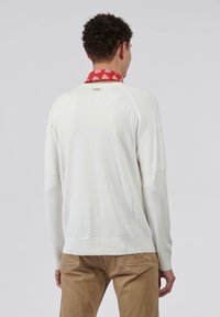 Pull en laine blanc avec des accents côtelés sur les épaules et les poignets, dotée d'un col rond et d'un ourlet droit.
