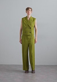 Gilet doppiopetto verde e pantaloni abbinati in tessuto strutturato. Vestibilità slim, design cropped con silhouette a gamba larga e una sartoria discreta.
