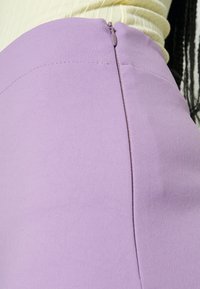 Lichtpaarse rok met een soepele textuur, voorzien van een zijrits en een naadloos ontwerp voor een gestroomlijnde uitstraling.