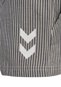 Randig tyg i marinblått och krämfärgat med en ficka som har ett vitt chevronmönster. Materialet verkar hållbart med en tydlig textur.