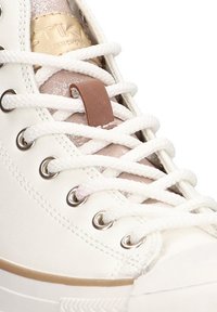 Zapatillas altas de cuero blanco con cordones trenzados, ojales metálicos y una correa de acento beige. Superficie texturizada con un acabado suave.