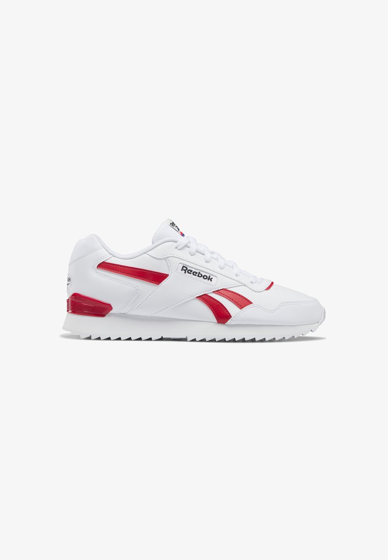 White athletic sneaker with red accents, featuring synthetic leather material, lace-up design, and a textured rubber sole for grip.