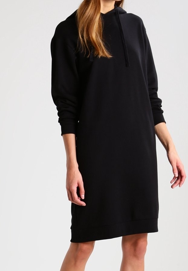 Svart huvtröjdress med långa ärmar, en avslappnad passform och ribbade muddar. Tillverkad av mjukt tyg med en rak nederkant.