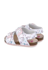Sandalias blancas con patrones de unicornios y nubes, hebillas rosas, plantilla de corcho y una suela texturizada rosa. Diseño destalonado.